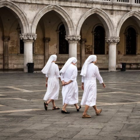 Drei Nonnen spazieren auf der Piazza San Marco (Foto: IMAGO, IMAGO / Greatstock)
