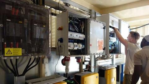 Dem Energiewirt, Techniker und Logistiker Jesse Pielke macht es Spaß, die Software des Solartainers auf den neuesten Stand zu bringen und malische Techniker auszubilden (Foto: SWR, Thomas Kruchem -)
