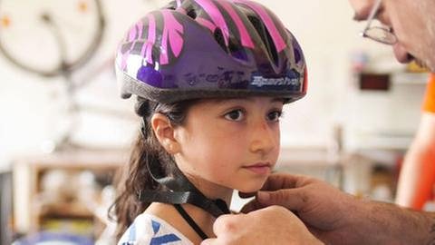 Ein kleines Mädchen bekommt einen Fahrradhelm aufgezogen (Foto: SWR, SWR -)