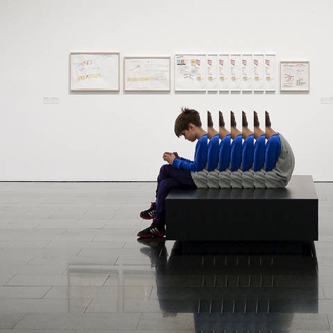 Junge sitzt im Museum (Foto: Unsplash)