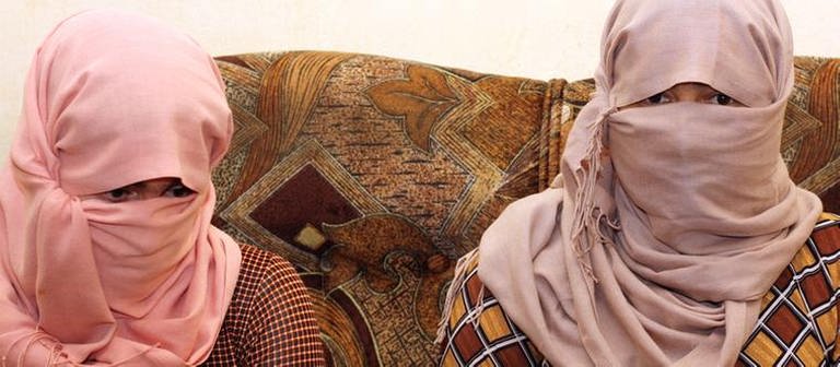 Mit verhüllten Gesichtern sitzen zwei jesidische Frauen bei einem Gespräch in Erbil (Irak) (Foto: picture-alliance / dpa, picture-alliance / dpa - Jan Kuhlmann)