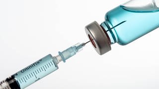 Spritze wird mit Impfstoff aufgezogen: Wissenschaftler weltweit arbeiten an neuartigen Impfstoffen und Medikamenten, die gegen ganze Virusfamilien wirken. Beispielsweise nicht nur gegen SARS-CoV-2, sondern gegen alle Corona-Viren.  (Foto: imago images, imago images / MiS)