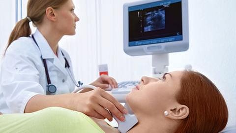Ärztin untersucht Patientin an der Schilddrüse. (Foto: Getty Images, Thinkstock -)