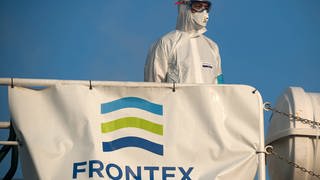 Ein Mitglied der Europäischen Grenz- und Küstenwache Frontex in einen Schutzanzug auf einem Patrouillenschiff im Hafen von Malaga (Foto: imago images, IMAGO / ZUMA Wire)