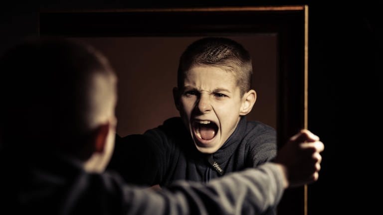 Ein Junge schreit wütend sein eigenes Spiegelbild an: Warum sind pubertierende Jungs so schwierig? (Foto: IMAGO, IMAGO / Panthermedia)