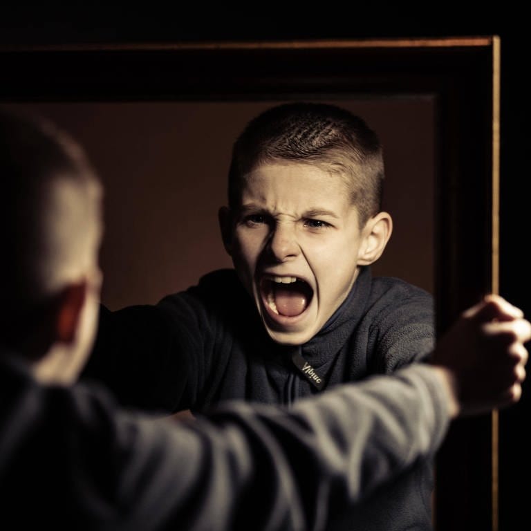 Ein Junge schreit wütend sein eigenes Spiegelbild an: Warum sind pubertierende Jungs so schwierig? (Foto: IMAGO, IMAGO / Panthermedia)