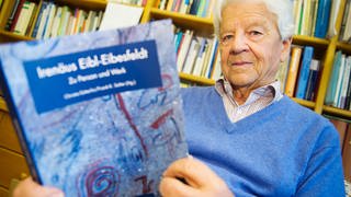 Der Humanethologe Irenäus Eibl-Eibesfeldt 2013 mit einem seiner Bücher (Foto: picture-alliance / Reportdienste, picture alliance / dpa | Inga Kjer)