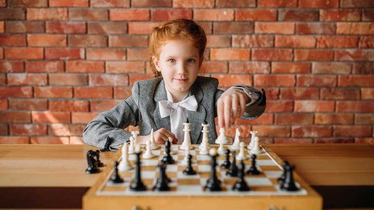 Ein Mädchen mit roten Haaren spielt Schach: Mit der Netflix-Serie „Damengambit“ wurde Schach populärer. Wer Schach spielt, gilt als schlau. Doch steigert es wirklich die Intelligenz? Was lässt sich dabei fürs Leben lernen? (Foto: picture-alliance / Reportdienste, IMAGO / Panthermedia)