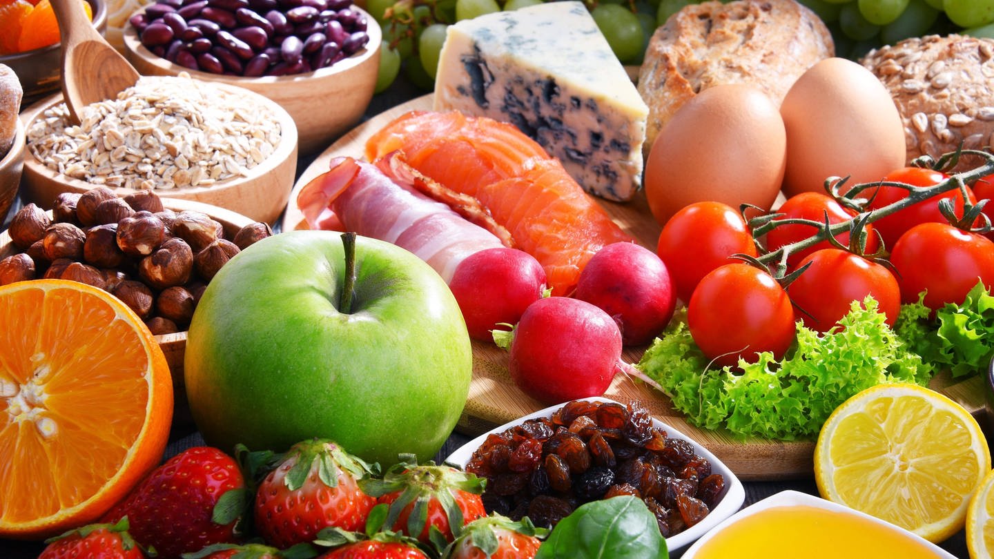 Reich gedeckter Tisch mit Obst, Gemüse, Nüssen, Eiern, Käse, Getreideprodukten: 