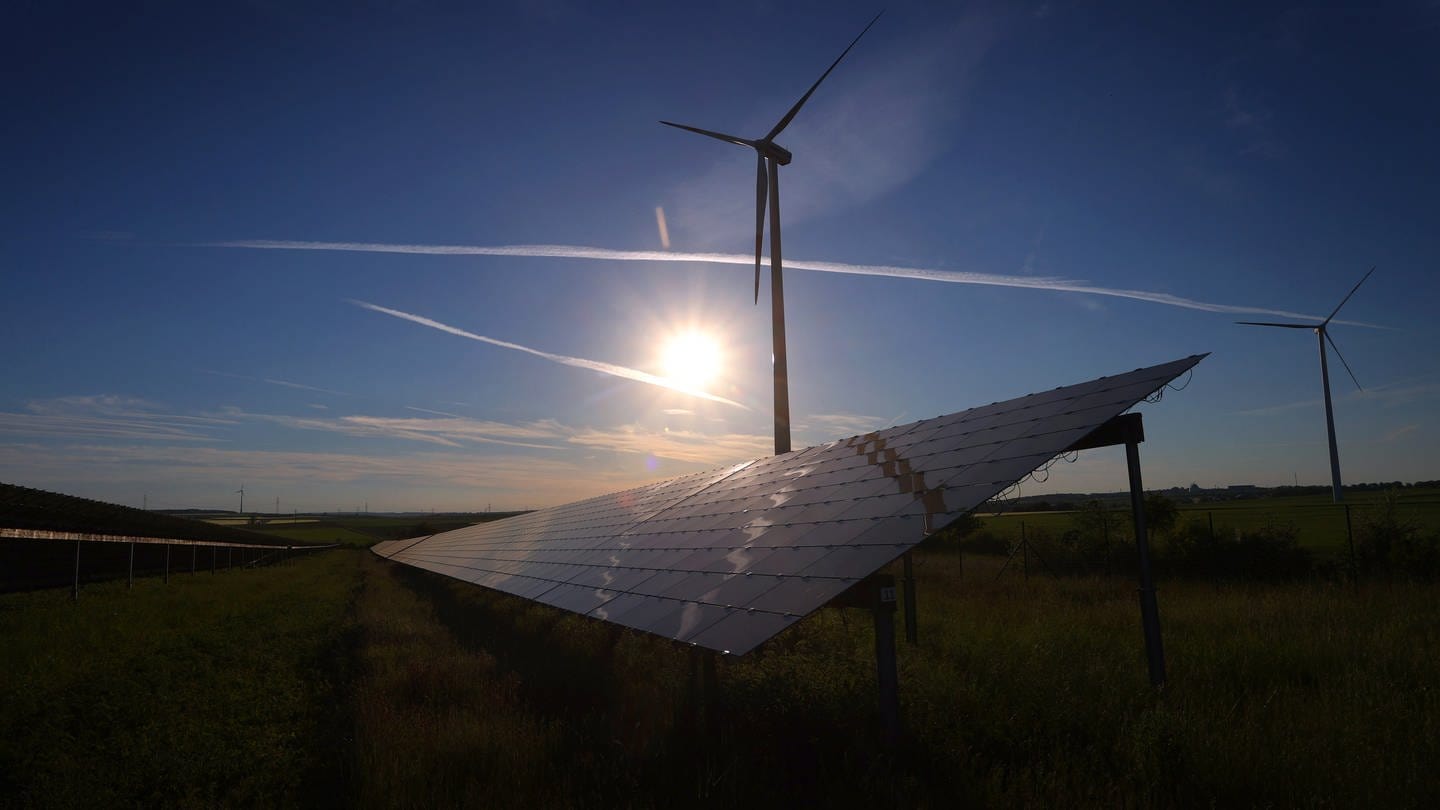 Windräder stehen hinter den Solarzellen einer Solarkraftanlage. (Foto: picture-alliance / Reportdienste, picture alliance/dpa | Karl-Josef Hildenbrand)
