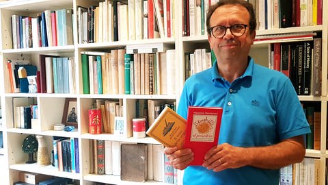 Der Historiker Massimo Montanari hält zwei seiner Bücher in die Kamera. Seit 1994 forscht er an der Universität Bologna zur Geschichte unserer Ernährung.   (Foto: SWR, Thomas Hillebrandt)