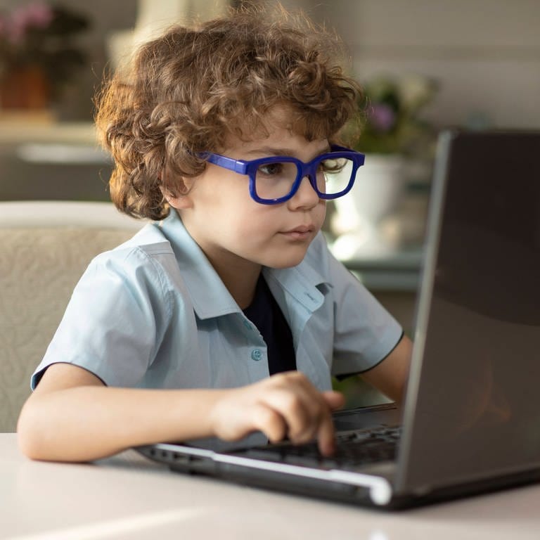 Junge mit Brille sitzt dicht vor einem aufgeklappten Laptop: Augenerkrankungen nehmen weltweit deutlich zu. Zwei Drittel aller Deutschen benötigen bereits eine Sehhilfe. Bei jungen Menschen steigt vor allem die Zahl der Kurzsichtigen. (Foto: IMAGO, IMAGO / YAY Images)