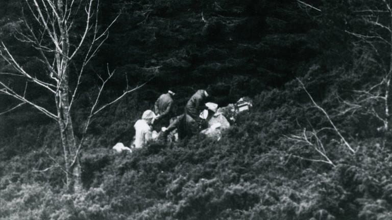 1970 wird im Isdal in Norwegen die verbrannte Leiche einer Frau gefunden. Die historische Aufnahme zeigt Ermittler am Tatort. (Foto: Police / Bergen State Archives)