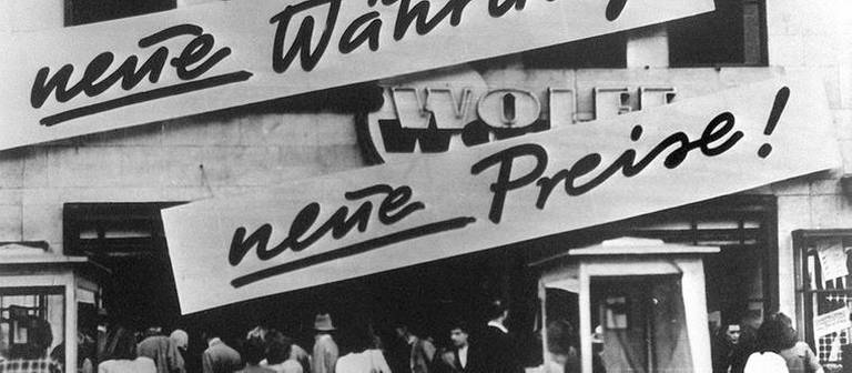 Kundenandrang vor einem Geschäft, das nach der Währungsreform 1948 Schilder mit der Aufschrift "Neue Währung... neue Preise!" an der Hausfassade angebracht hat. (Foto: picture-alliance / Reportdienste, picture-alliance / Reportdienste -)