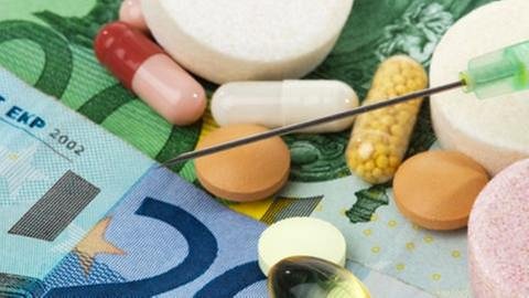 Auf diversen Geldscheinen liegen Medikamente ausgebreitet. (Foto: Getty Images, Thinkstock -)