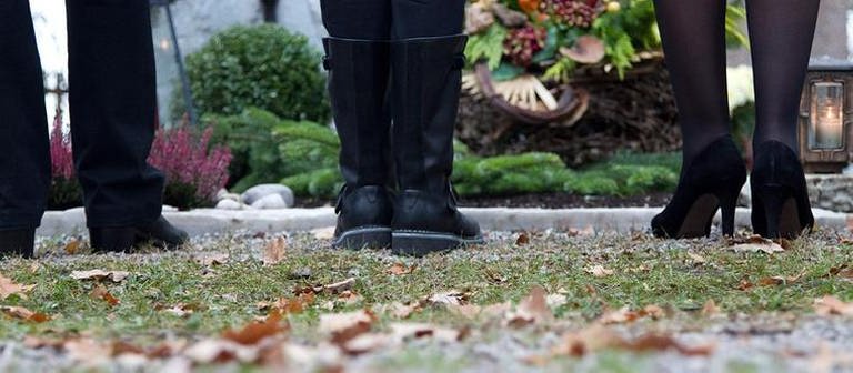 Drei Personen stehen vor einem Grab (Foto: Getty Images, Thinkstock -)