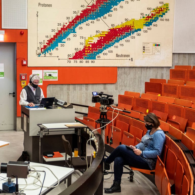 Bis auf Dozent und Kamerafrau leerer Hörsaal: Online-Vorlesung für Physik-Erstsemester an der TU Dortmund (Foto: IMAGO, IMAGO / Olaf Döring)
