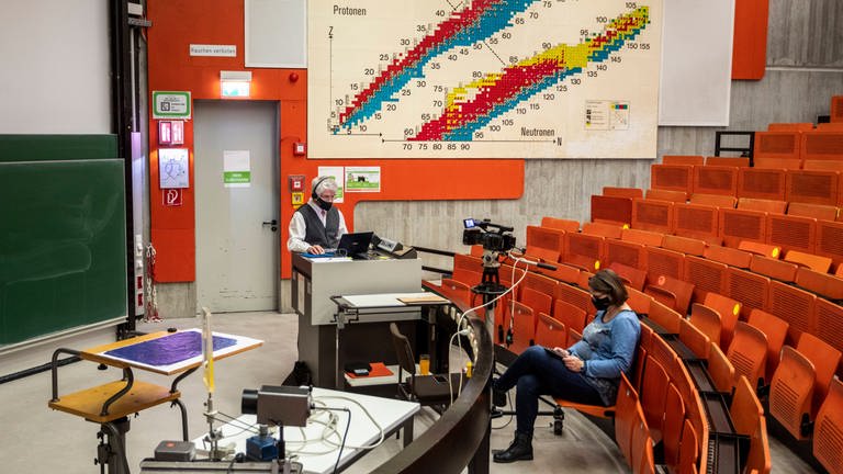 Bis auf Dozent und Kamerafrau leerer Hörsaal: Online-Vorlesung für Physik-Erstsemester an der TU Dortmund (Foto: IMAGO, IMAGO / Olaf Döring)