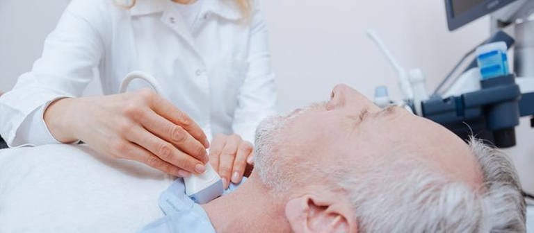 Ein älterer Mann wird an der Schilddrüse mit Ultraschall untersucht. (Foto: Getty Images, Thinkstock -)