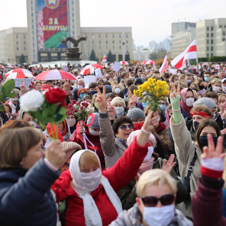 Demonstrantinnen halten während einer Kundgebung der Opposition am 26. Oktober 2020 in Minsk Blumen und protestieren gegen die offiziellen Ergebnisse der Präsidentschaftswahlen in Belarus (Foto: picture-alliance / Reportdienste, picture alliance / ASSOCIATED PRESS | Uncredited)