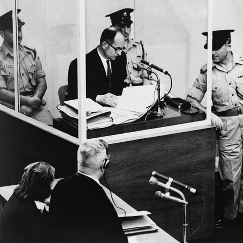 Adolf Eichmann sagt bei seinem Kriegsverbrecherprozess 1961 in Jerusalem aus. Eichmann wird von seinem Anwalt Robert Servatius (unten links) befragt. Eichmann wurde für schuldig befunden, die Massendeportation von Juden in Vernichtungslager in den von Deutschland besetzten Gebieten organisiert zu haben. (Foto: IMAGO, IMAGO / Everett Collection)