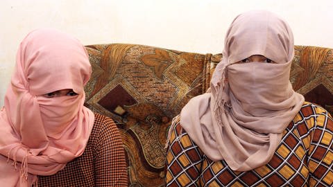 Mit verhüllten Gesichtern sitzen zwei jesidische Frauen am 10.6.2015 bei einem Gespräch in Erbil (Irak). Die Geschwister waren mehrere Monate in der Gewalt des IS. (Foto: dpa Bildfunk, picture alliance / dpa | Jan Kuhlmann)