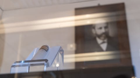 Friedrich Miescher (1844 - 1895): Sein Bild im Museum der Universität Tübingen hinter einem Reagenzglas mit isolierter Nukleinsäure aus Lachssperma aus den Originalbeständen (Foto: dpa Bildfunk, picture alliance/dpa | Sebastian Gollnow)