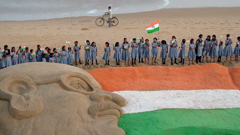 Sandskulptur einer indischen Nationalflagge und eines Mahatma-Gandhi-Porträts, geschaffen vom Sandkünstler Sudarshan Pattnaik  (Foto: picture-alliance / Reportdienste, Picture Alliance)
