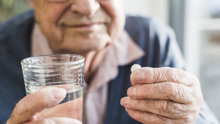 Ein Senior nimmt eine Tablette (Foto: IMAGO, imago images / Westend61)