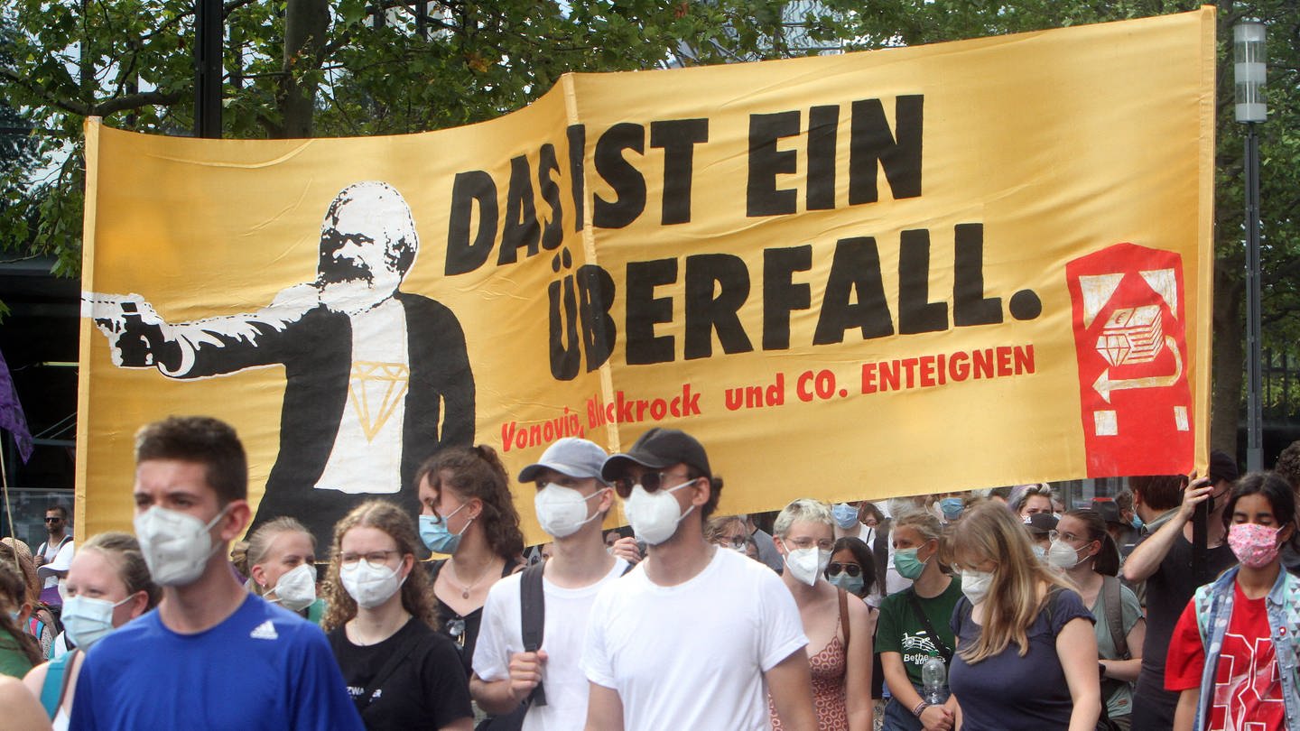 Demonstration der Fridays-For-Future-Bewegung am 13.8.2021 in Frankfurt. Aktivisten tragen ein Transparent mit dem Konterfei von Karl Marx und der Forderung nach Enteignung von Vonovia und Blackrock