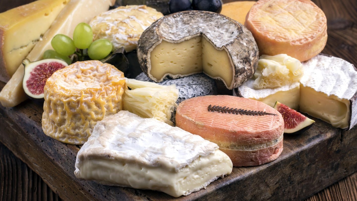 Verschiedene Käsesorten auf einem Holzbrett: Viele Leute schneiden die Rinde beim Käse weg, das wäre aber in den meisten Fällen zumindest aus gesundheitlichen Gründen nicht nötig. (Foto: picture-alliance / Reportdienste, picture alliance / Zoonar | H.LEITNER)
