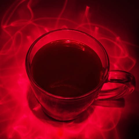 Eine Tasse Kaffee mit Laserstrahlen drumrum (Foto: IMAGO, IMAGO / agefotostock)