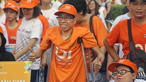 Der Vietnamese Nguyen Duc (Mitte), offenbar aufgrund der Nachwirkungen des Entlaubungsmittels Agent Orange, das vom US-Militär während des Vietnamkriegs eingesetzt wurde, als siamesischer Zwilling geboren, beim Start eines Charity-Marathon-Events in Ho-Chi-Minh-Stadt 2019 (Foto: picture-alliance / Reportdienste, picture alliance/dpa)