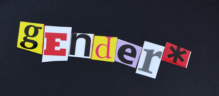 Gendersternchen auf schwarzem Untergrund: "gender" in bunten Buchstaben ausgeschrieben, dahinter ein Sternchen (Foto: picture-alliance / Reportdienste, picture alliance | Christian Ohde)