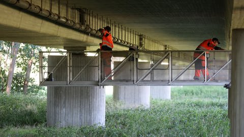 Mitarbeiter vom Straßenbauamt unterziehen eine Brücke einer Prüfung.  (Foto: picture-alliance / Reportdienste, picture alliance/dpa | Bernd Wüstneck)