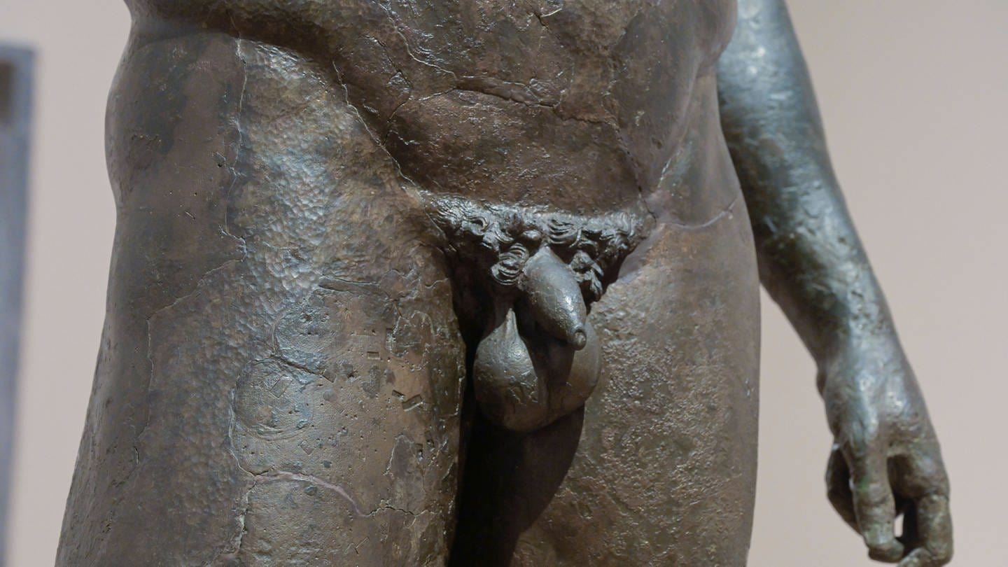 Die Detailaufnahme des Penis einer antiken Bronzestatue (Foto: IMAGO, IMAGO / Schöning)
