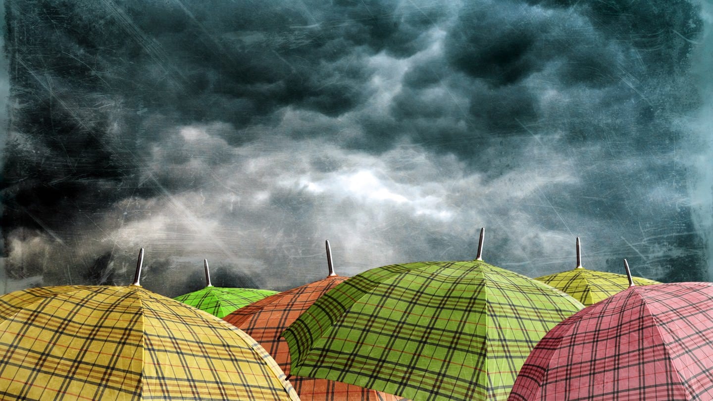 Regenschirme und dunkle Gewitterwolken: Wetter- und Klimaprognosen funktionieren zwar unterschiedlich – aber nähern sich immer mehr an. Mit welchen Tricks die Vorhersagen immer besser werden. (Foto: Colourbox)