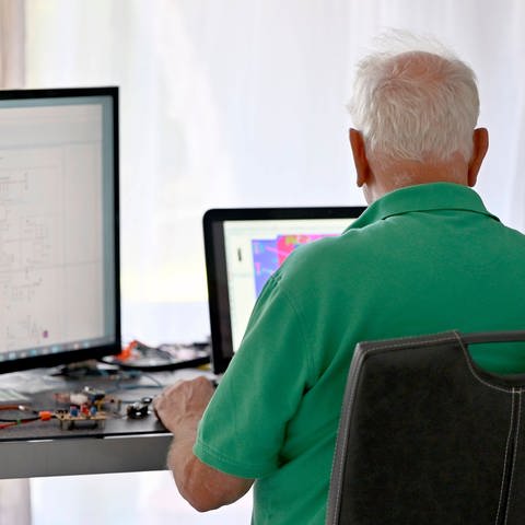 Ein Senior arbeitet in seiner Elektronik-Werkstatt (Foto: IMAGO, IMAGO / Panama Pictures)