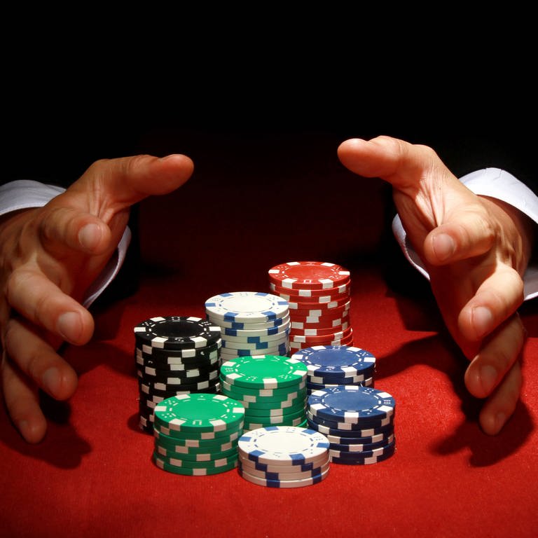 Ein Poker-Spieler mit seinen Jetons (Foto: IMAGO, IMAGO / Wirestock)