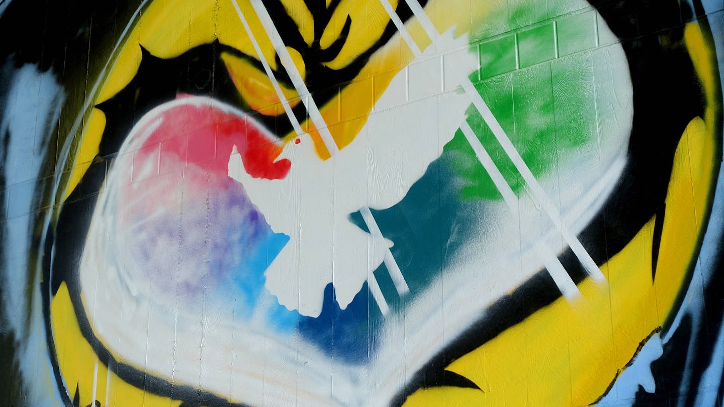 Graffiti mit weißer Friedenstaube in einem farbigen Herzen: Während der Friedensbewegung der 1980er- und 1990er-Jahre galt der Pazifismus als respektable politisch-ethische Haltung. Das hat sich mit dem russischen Angriffskrieg gegen die Ukraine geändert. (Foto: IMAGO, IMAGO / Müller-Stauffenberg)