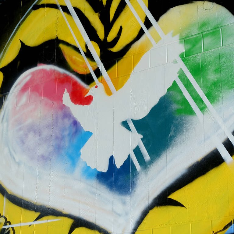 Graffiti mit weißer Friedenstaube in einem farbigen Herzen: Während der Friedensbewegung der 1980er- und 1990er-Jahre galt der Pazifismus als respektable politisch-ethische Haltung. Das hat sich mit dem russischen Angriffskrieg gegen die Ukraine geändert.  (Foto: IMAGO, IMAGO / Müller-Stauffenberg)