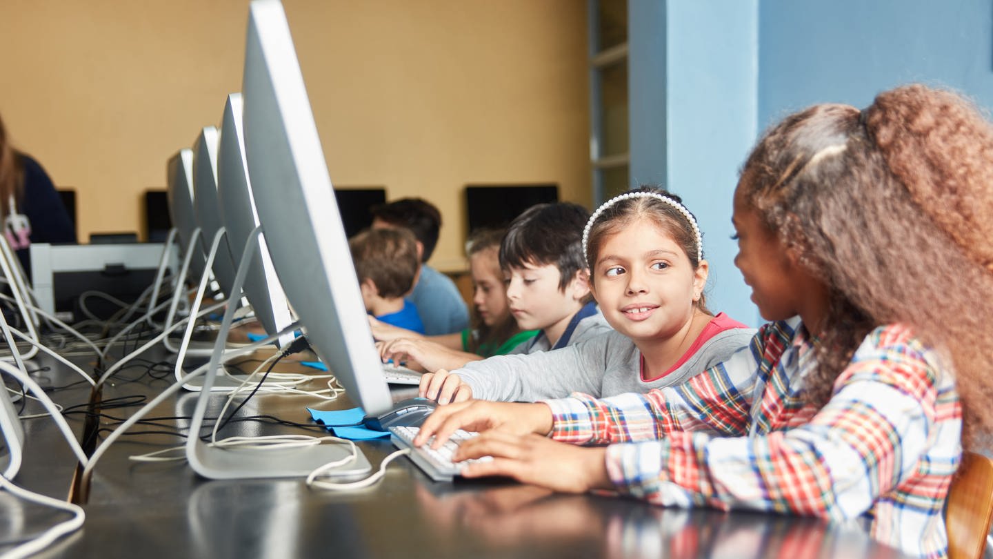 Kinder lernen im Informatik-Unterricht am Computer in der Grundschule: Ende 2022 forderten Bildungsexpert*innen, endlich Informatik an allen Schulen in Deutschland als Pflichtfach einzuführen. Im europäischen Vergleich liegt Deutschland weit zurück; in den meisten Bundesländern ist Informatik bisher lediglich Wahlpflichtfach. Das soll sich ändern. (Foto: picture-alliance / Reportdienste, picture alliance / Zoonar | Robert Kneschke)