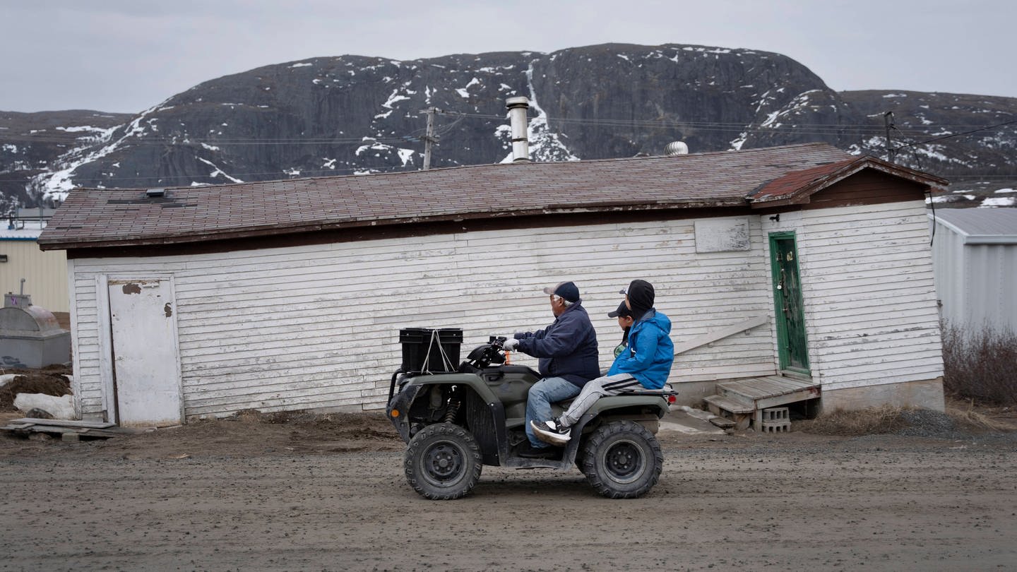 Kanada: Einheimische fahren an einem durch Erwärmung des Permafrostes, geneigten, schiefen Gebäude vorbei. (Foto: IMAGO, IMAGO / ZUMA Press)