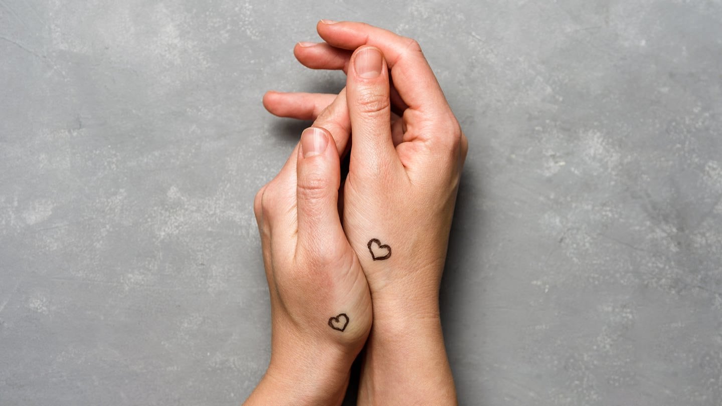 Hände mit Herzen tätowiert auf grauem Betonhintergrund (Foto: IMAGO, IMAGO / Pond5 Images)