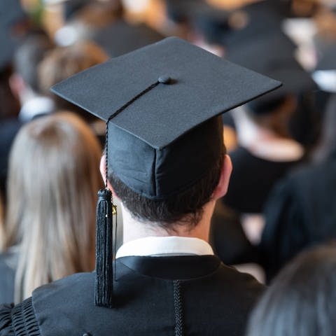 Absolventen der Universität Mannheim tragen während der Abschlussfeier in der Aula Absolventenhüte. (Foto: IMAGO, IMAGO / Silas Stein)