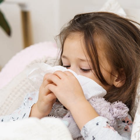 Ein Kind liegt krank im Bett. (Foto: IMAGO, IMAGO / Pond5 Images)