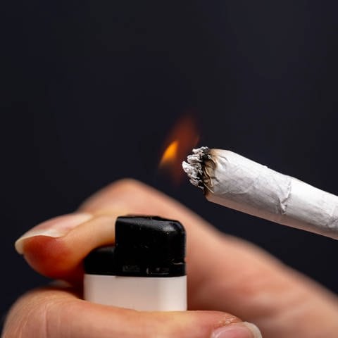 Thema Cannabis-Legalisierung (Symbolbild), Raucherin zündet sich einen Joint an. (Foto: IMAGO, IMAGO / MiS)