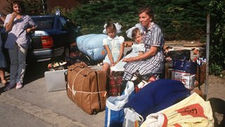 Aussiedler aus Kasachstan sitzen am 21. August 1989 im Lager Schöppingen auf ihren gepackten Koffern. Sie werden verlegt, um Platz für Flüchtlinge aus der DDR zu machen.  (Foto: picture-alliance / Reportdienste, Franz-Peter Tschauner)