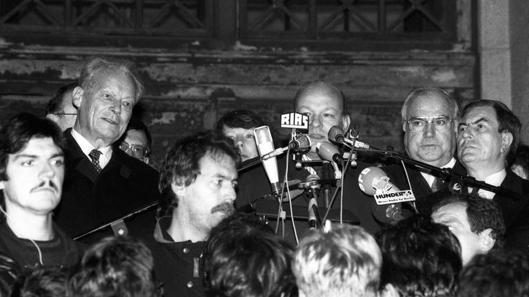 Walter Momper (Mitte, SPD, Regierender Bürgermeister Berlin) neben Bundeskanzler Helmut Kohl (2.v.re., CDU) und Willy Brandt (li., SPD) während einer Kundgebung vor dem Schöneberger Rathaus in Berlin am 10.11.1989 (Foto: IMAGO, imago/Dieter Bauer)