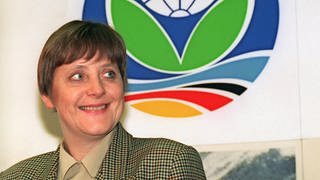 Bundesumweltministerin Angela Merkel vor dem Logo der UN-Klimakonferenz, die vom 28. März bis 7. April 1995 in Berlin stattfindet (Foto: picture-alliance / Reportdienste, dpa)